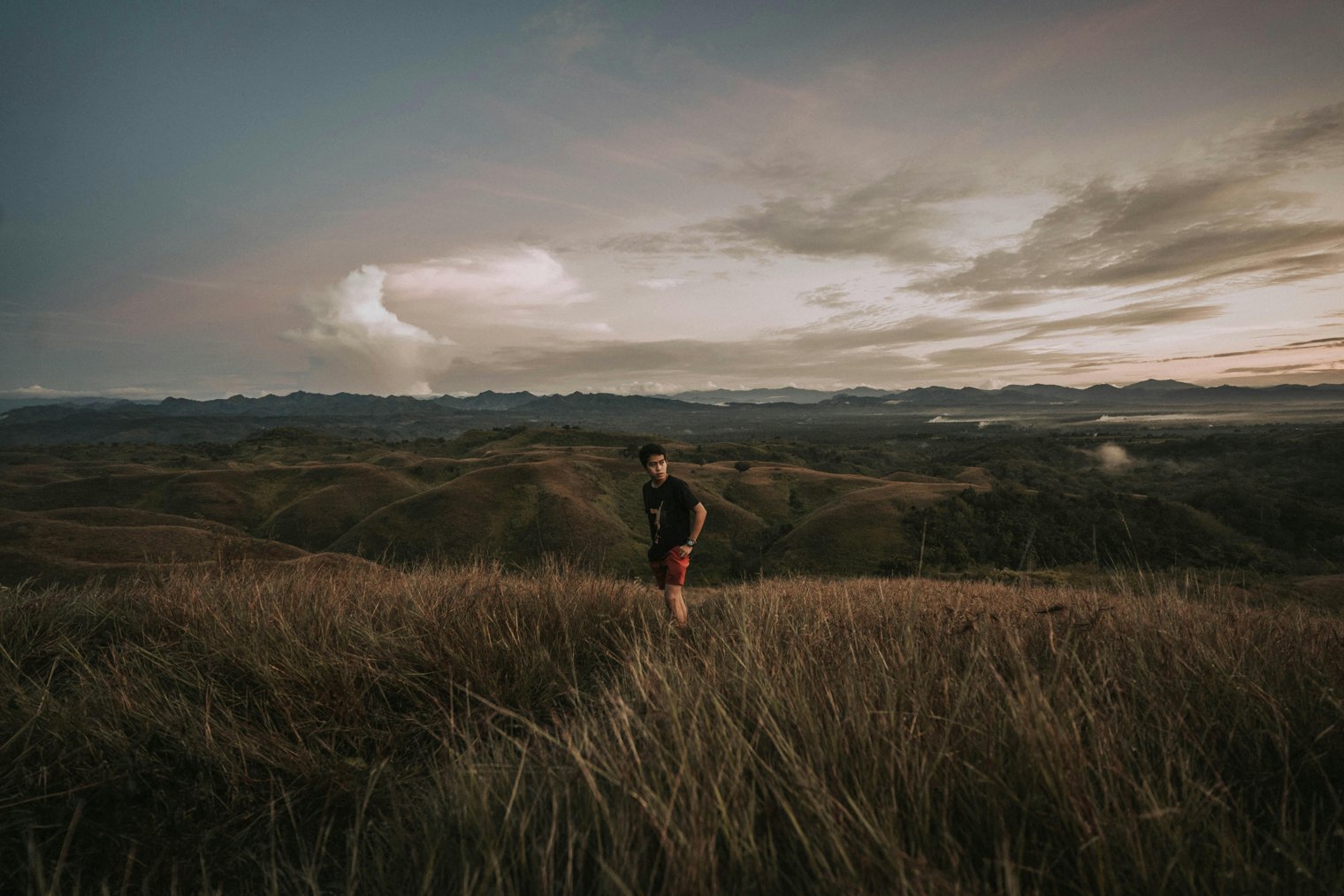 Standing Alone in a Wide Open Field at Sunset, Watching the Clouds Turn Pink and Orange